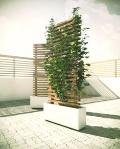 a tall planter sitting on top of a brick floor next to a wooden fence