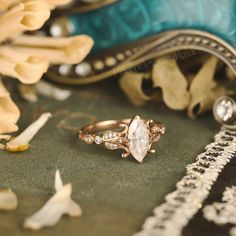 a diamond ring sitting on top of a table next to other jewelry items and flowers