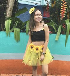 a young woman wearing a yellow tutu skirt and sunflowers on her waist