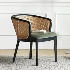 a chair sitting on top of a rug in front of a white wall next to a table