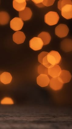 a close up of an apple on a table with blurry lights in the background