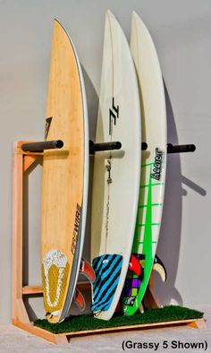 three surfboards are standing on a shelf