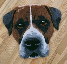 a brown and white dog laying on top of a wooden floor next to a rug