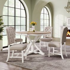 a dining room table with four chairs and a fireplace in the backgrounge