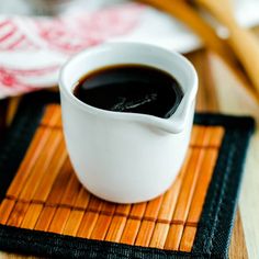 a cup of coffee sitting on top of a bamboo mat