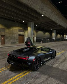 a black sports car parked in an empty parking garage