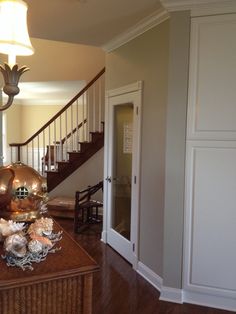 a vase with flowers sitting on top of a table next to a stair case in a house