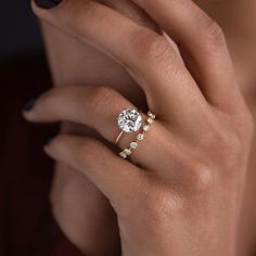 a woman's hand with a ring on her finger and a diamond in the middle