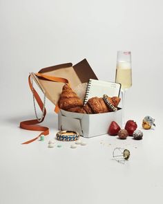 a basket filled with croissants and pastries next to a glass of milk