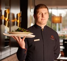 a man holding a plate with food on it