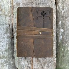 a brown leather journal sitting on top of a tree