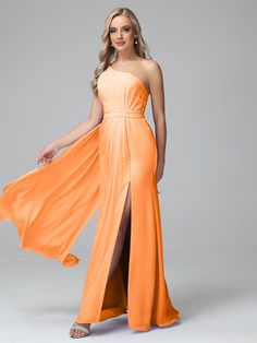 a woman in an orange dress poses for the camera with her long, flowing skirt