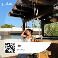 a woman sitting on top of a wooden bench in front of a building with a qr code attached to it