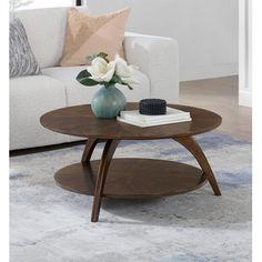 a living room with a couch, table and flowers on the coffee table in front of it