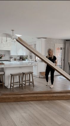 a woman is standing in the middle of an open floor plan with stairs going up and down