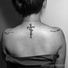 a woman with a cross tattoo on her back