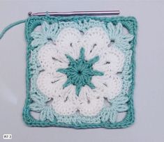 a crocheted square with a flower on it