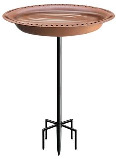 a round table with an iron base and circular tray on the top, sitting on a black metal stand