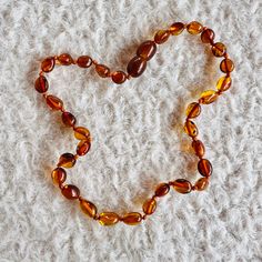 a necklace made out of glass beads on a white surface