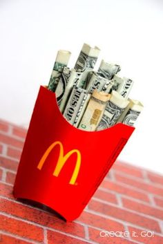 a mcdonald's bag full of money sitting on top of a red brick wall