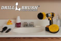 a bathroom sink with a yellow brush on it's head and two rubber ducks sitting next to it