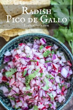 a bowl filled with red onions and cilantro next to tortilla chips