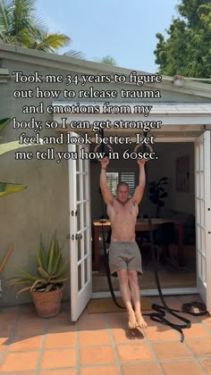 a shirtless man with his arms up in the air while standing inside an open door