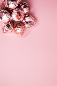 a bunch of silver objects sitting on top of a pink surface