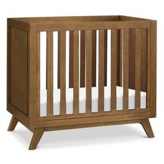 a small wooden crib with white sheets