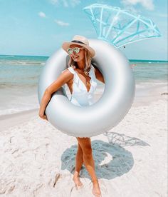 a woman is standing on the beach with an inflatable ring around her neck