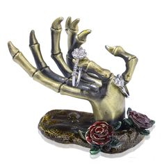 a statue of a hand holding two roses on top of a piece of glass and metal