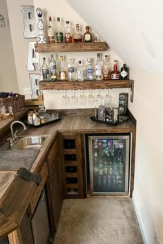 a small kitchen with an ice chest in the corner and shelves on the wall above it