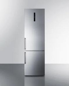 a silver refrigerator sitting in the middle of a room next to a white wall and floor