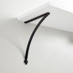 the corner of a white wall with a black handle on it