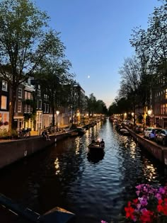 a canal filled with lots of boats on top of it's sides next to tall buildings