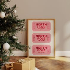 a christmas tree with presents under it in front of a poster that says north pole and north pole