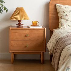 a bedroom with a bed, nightstand and lamp on the side table next to it