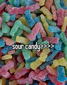 the words sour candy are in front of a pile of gummy bears