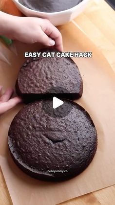 two chocolate cakes sitting on top of a wooden cutting board