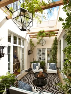 an outdoor living room with white furniture and potted plants