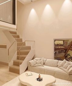 a living room with white furniture and stairs