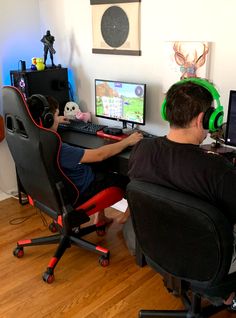 a man sitting in front of a computer desk with headphones on and playing games