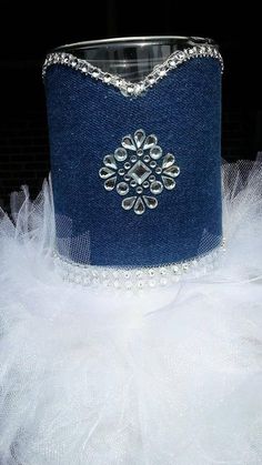 a blue hat with white tulle around it and a crystal brooch on the top