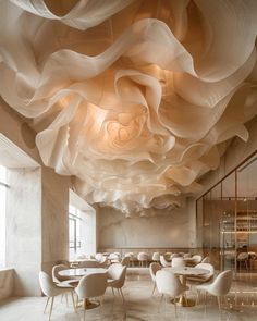 an elegant restaurant with white chairs and large chandeliers hanging from the ceiling above