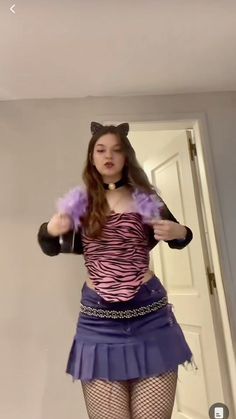 a woman in a purple top and blue skirt is dancing with her hands on her hips