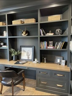 a home office with built - in bookcases and leather chair