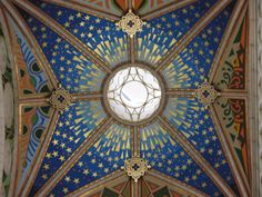 an ornate ceiling with a circular window in the center and stars on it's sides