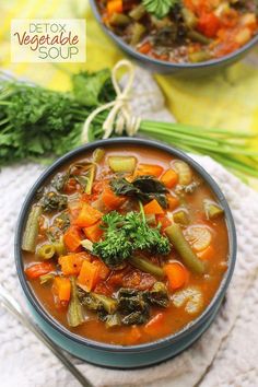 two bowls filled with vegetable soup on top of a table