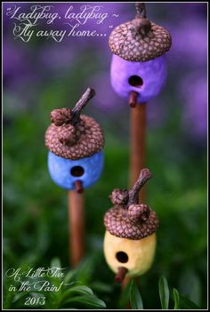 three little bird houses sitting on top of wooden sticks