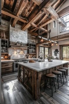 a large kitchen with an island and wooden beams on the ceiling, surrounded by wood flooring